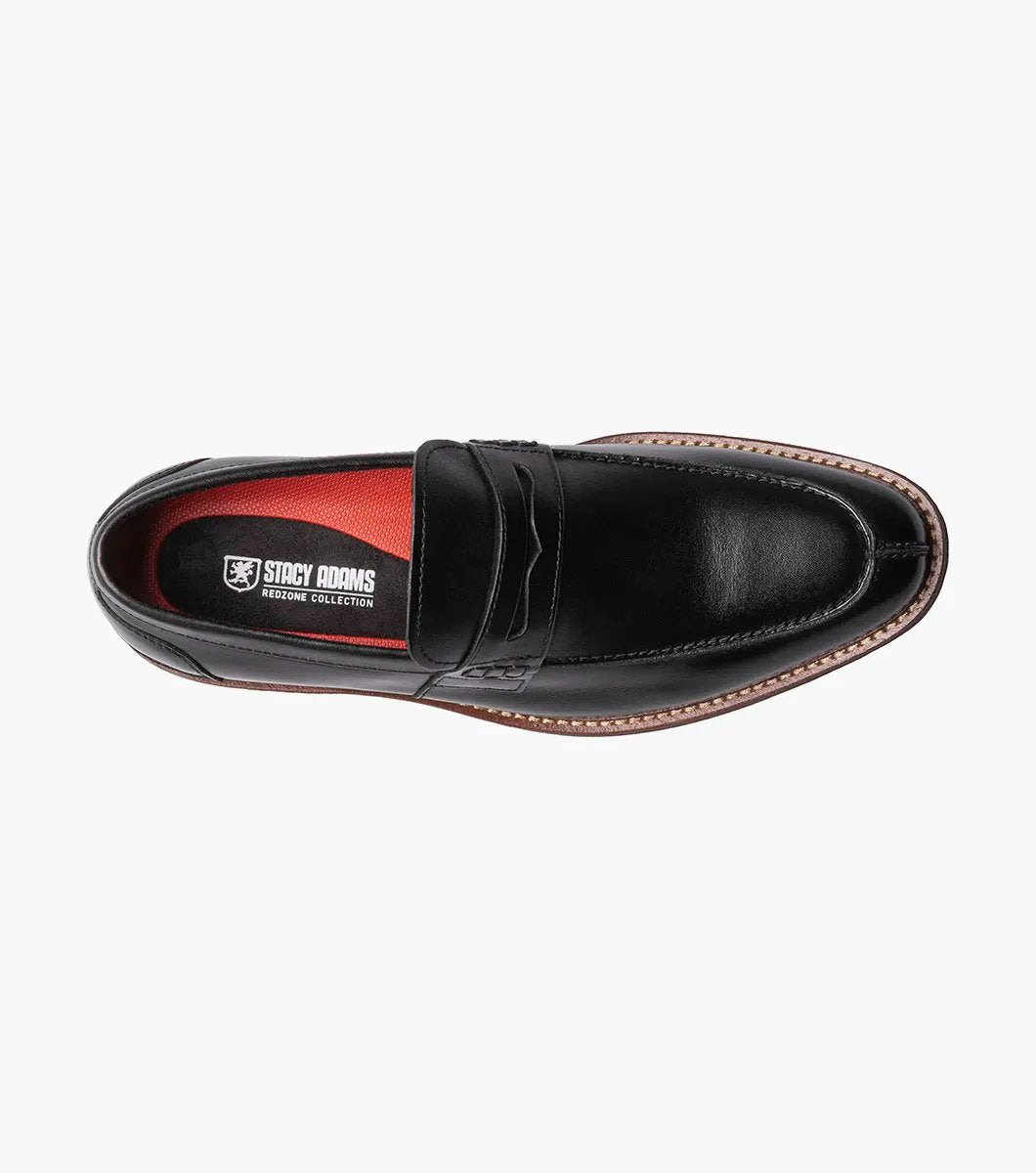 The Stacy Adams MARLOWE Algonquin Moc Toe Penny Slip On in black, featuring a refined leather upper and a contrasting brown sole, is displayed against a plain background.