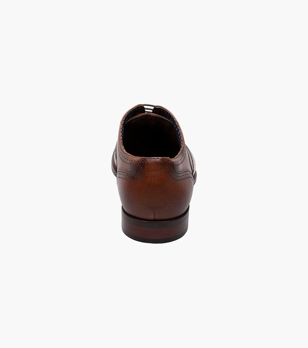 The Stacy Adams KAINE Wingtip Oxford in Cognac, model number 25569-221, from STACY ADAMS, is showcased against a white background, highlighting its intricate stitching and decorative perforations.