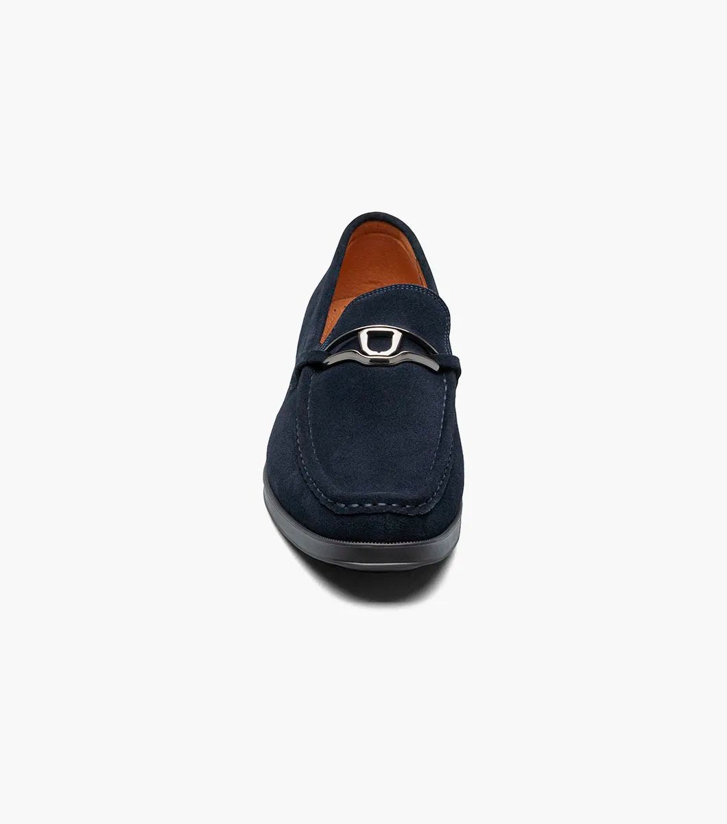 Stacy Adams introduces the PALLADIAN Moc Toe Slip On in Navy Suede (25549-415), showcasing a soft suede upper, metallic buckle detail, and black sole with a fully cushioned insole for exceptional comfort.