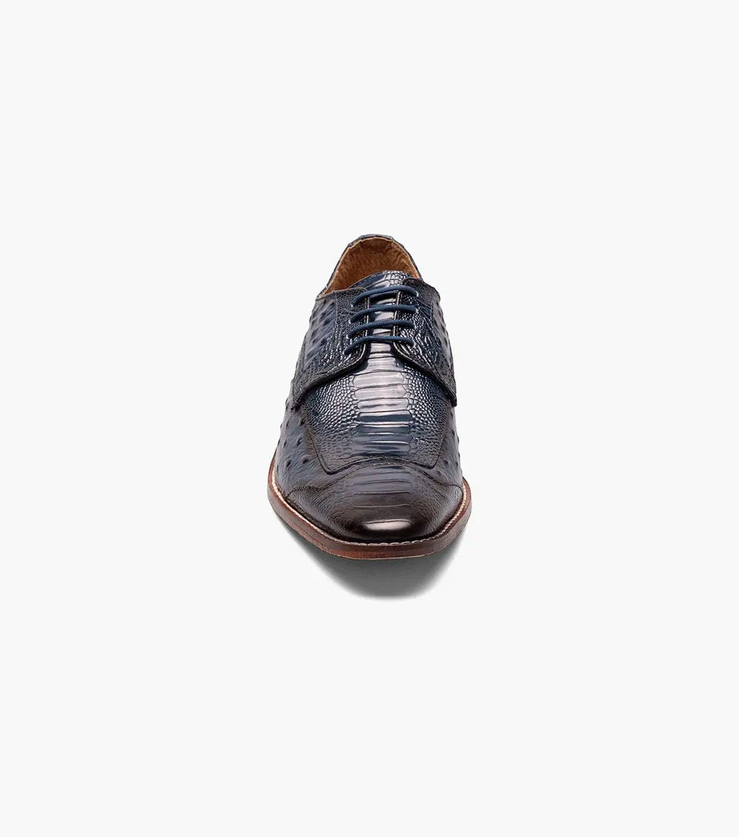 The Stacy Adams FANELLI Modified Wingtip Oxford in blue, product number 25536-400, is an elegant dress shoe made from luxurious ostrich leather. It features a textured pattern and a brown sole, shown here from an angled view.