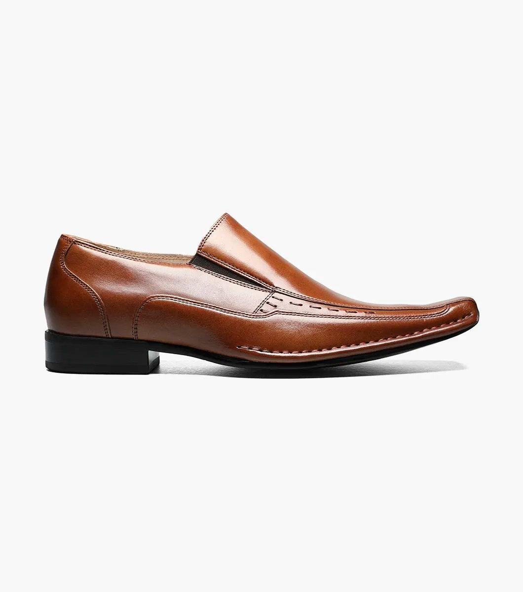 Stacy Adams' TEMPLIN Bike Toe Loafer in cognac showcases a genuine leather design with a stylish pointed toe and subtle stitching detail, set on a black sole. This elegant shoe features a cushioned insole for enhanced comfort, all highlighted against a plain background.