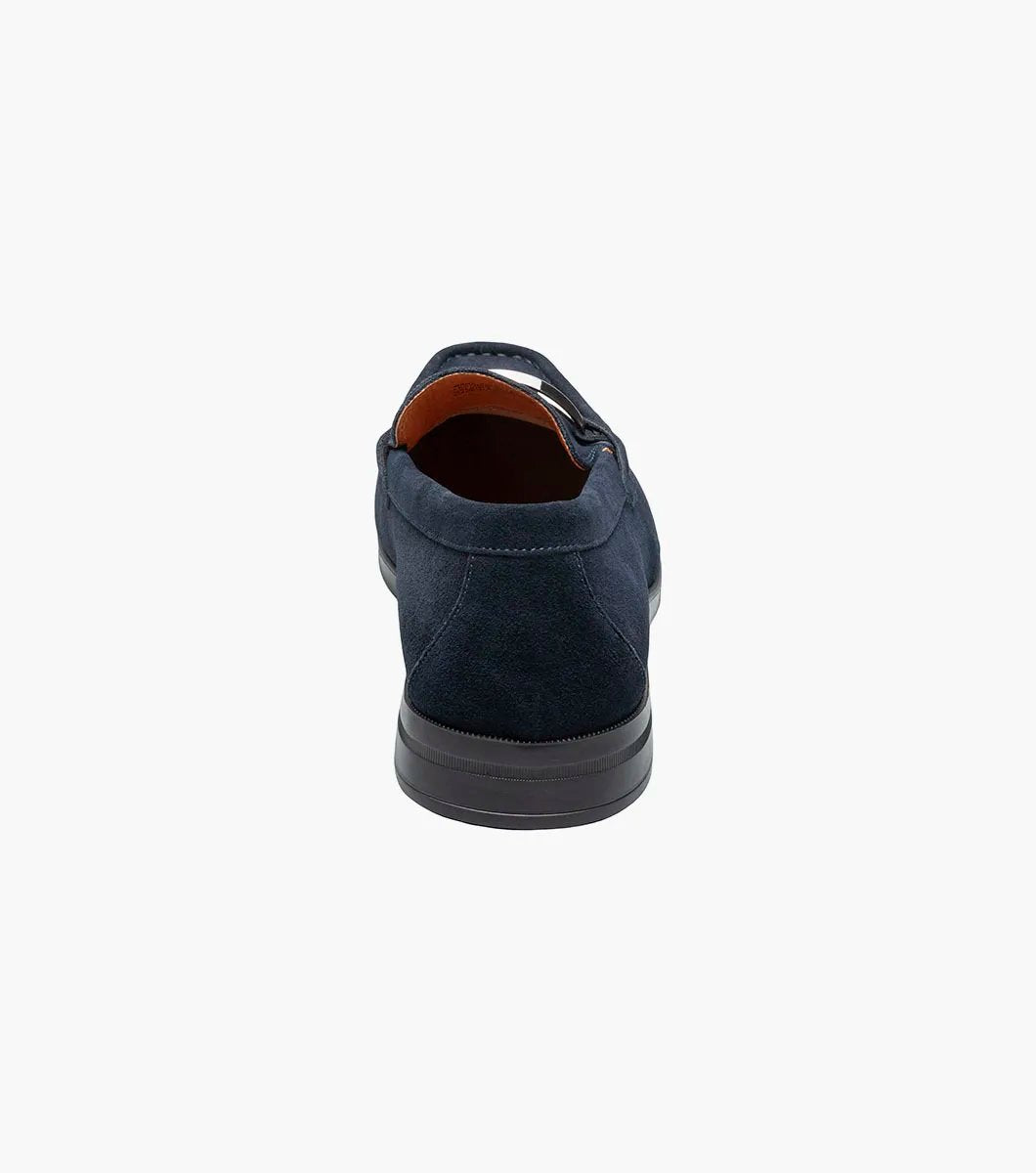 Stacy Adams introduces the PALLADIAN Moc Toe Slip On in Navy Suede (25549-415), showcasing a soft suede upper, metallic buckle detail, and black sole with a fully cushioned insole for exceptional comfort.