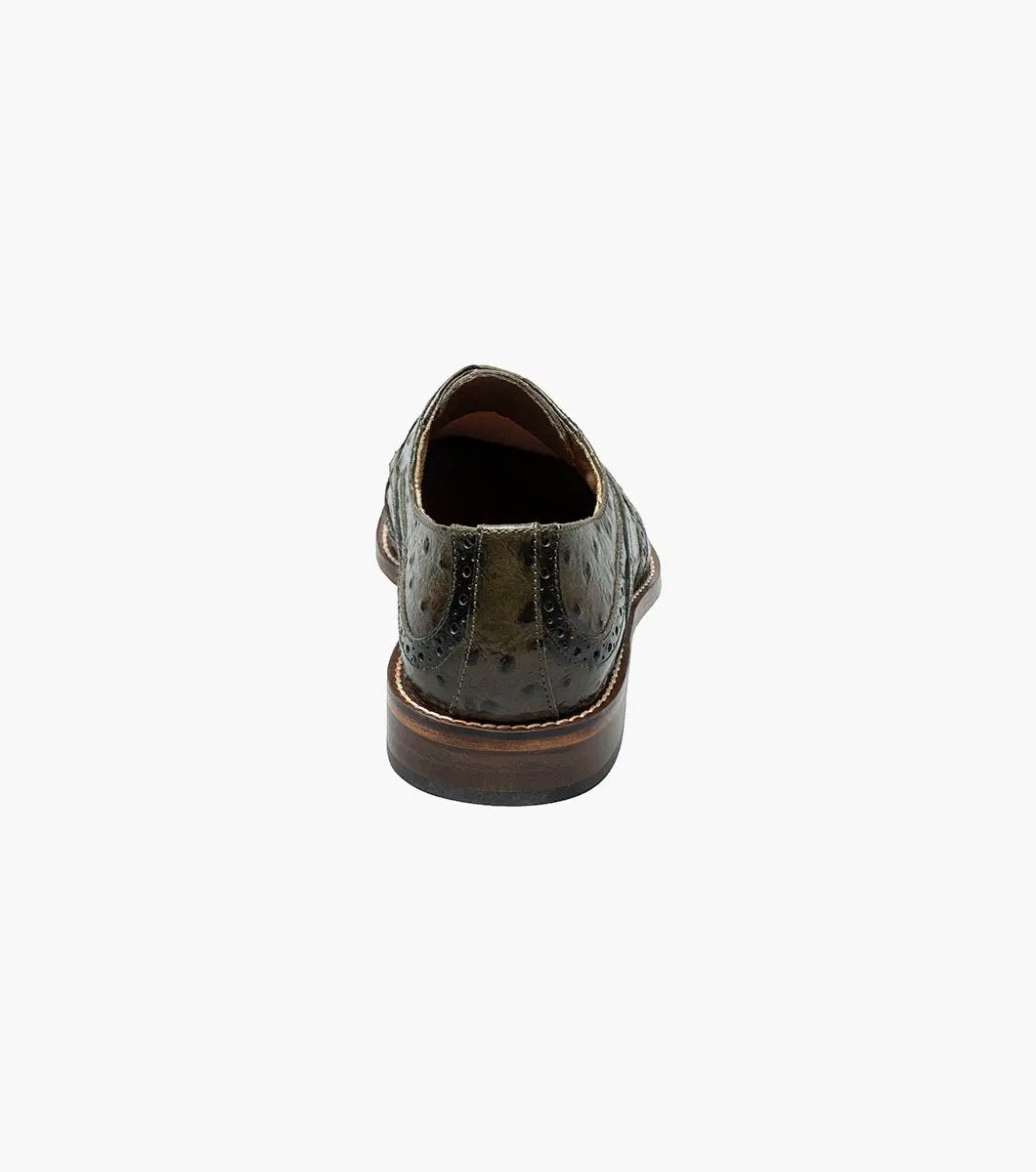 The Stacy Adams GENNARO Wingtip Oxford in olive (25537-303) is a refined shoe crafted from ostrich quill print leather, showcasing a textured pattern with brogue detailing, and includes a RedZone removable footbed for enhanced comfort.