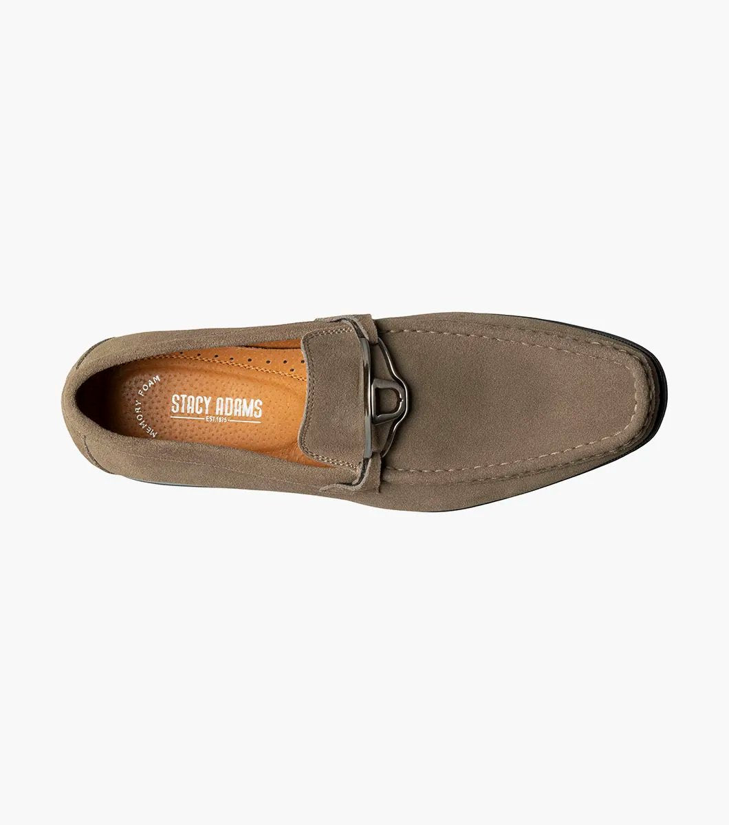 The Stacy Adams PALLADIAN Moc Toe Slip On in Fossil Suede features a brown suede leather design with a black sole, adorned with a silver buckle detail on top, and enhanced with memory foam for ultimate comfort.