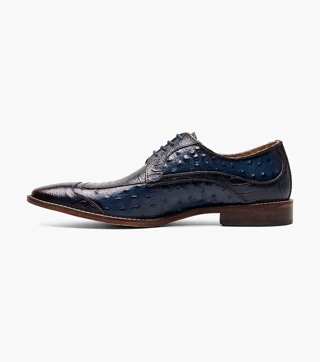 The Stacy Adams FANELLI Modified Wingtip Oxford in blue, product number 25536-400, is an elegant dress shoe made from luxurious ostrich leather. It features a textured pattern and a brown sole, shown here from an angled view.