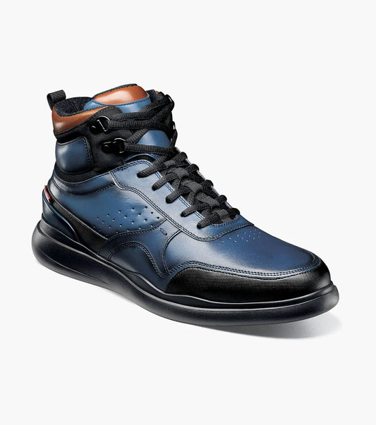 The Stacy Adams MAYSON U-Bal Lace Up Sneaker in blue, product number 25562-400, is a high-top sneaker boot from STACY ADAMS featuring black laces and brown ankle accents. It includes a RedZone footbed for ultimate comfort and is set against a plain white background.