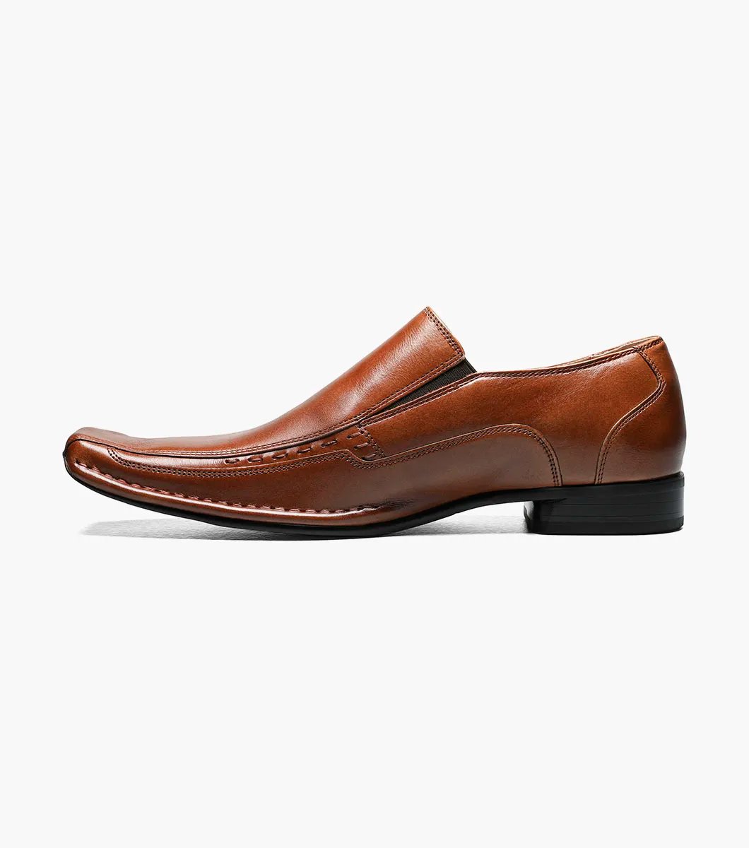 Stacy Adams' TEMPLIN Bike Toe Loafer in cognac showcases a genuine leather design with a stylish pointed toe and subtle stitching detail, set on a black sole. This elegant shoe features a cushioned insole for enhanced comfort, all highlighted against a plain background.