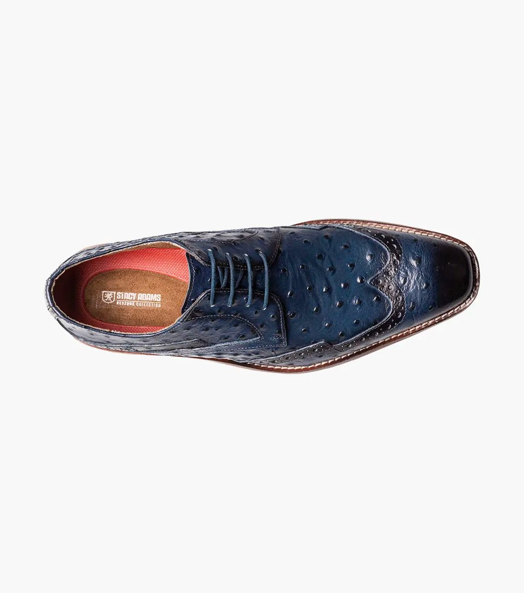 This blue Stacy Adams Gennaro Wingtip Oxford, featuring a textured ostrich quill print finish and a brown sole, elegantly captures the refined style associated with the Stacy Adams brand.