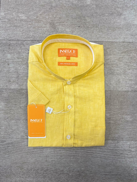 Displayed on a wooden surface is a Premium Linen Banded Collar Short Sleeve Shirt in yellow, complete with tags, from Inserch.