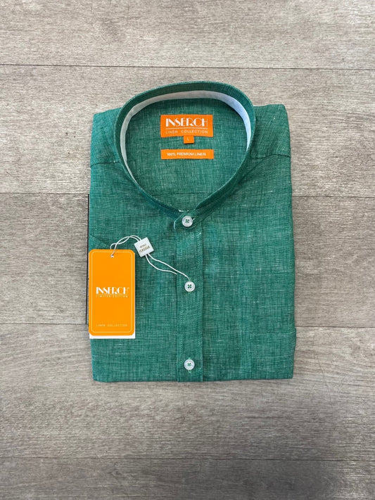 The Premium Linen Banded Collar Short Sleeve Shirt in green from Inserch, complete with white buttons and tags attached, is displayed folded on a wooden surface.